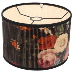 a lamp shade with flowers and butterflies painted on the fabric, hanging from a metal rod