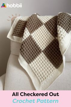 a crocheted blanket sitting on top of a white couch