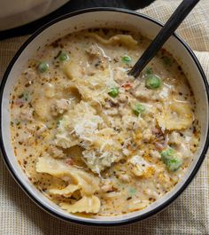 a white bowl filled with pasta and meat soup next to a pot of broccoli