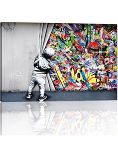 a little boy standing in front of a graffiti covered wall