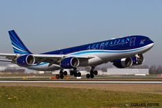 a large blue and white airplane is on the runway at an air port run way