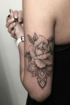 a woman's arm with a rose tattoo on the left side of her arm