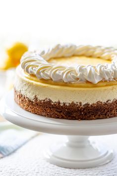 a cake with white frosting sitting on top of a white cake platter next to a napkin