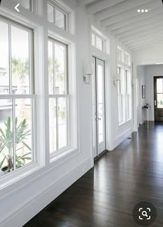 an empty hallway with wood floors and white walls