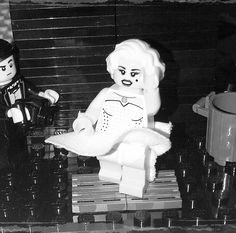 a lego man and woman sitting on a bench