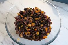 a glass bowl filled with raisins on top of a marble counter