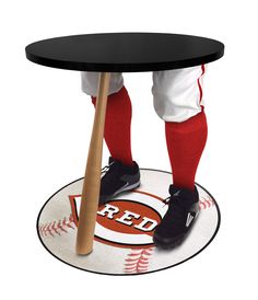 a baseball player standing on top of a table with a bat in his hand and red socks