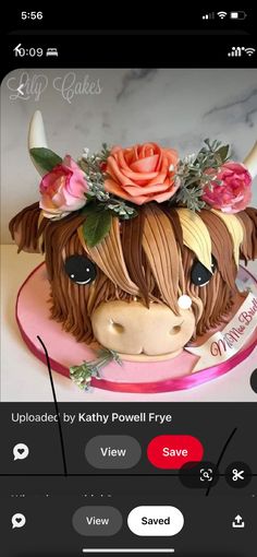 the cake is decorated like a cow with flowers on it's head and ears