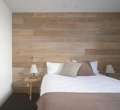 a bed room with a neatly made bed and wooden walls