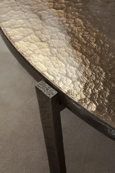 a close up of a metal table on carpeted floor with no one around it