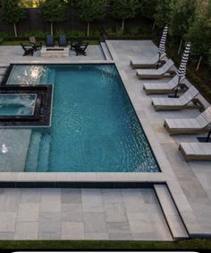 an aerial view of a swimming pool with lounge chairs