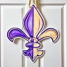 a purple and yellow fleur de lis hanging on a door