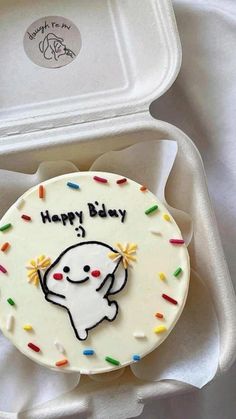 a birthday cake in a white box with sprinkles and an elephant on it