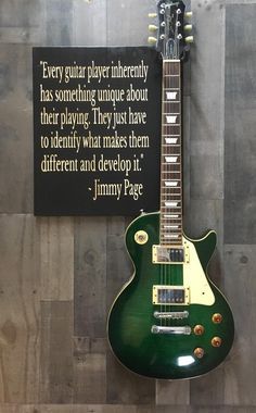 a green guitar hanging on the wall next to a sign that says, every guitar player intended has something unique about their playing