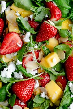 a salad with spinach, pineapples, strawberries and feta cheese