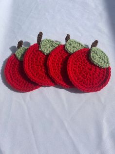 three crocheted apples sitting on top of a white sheet