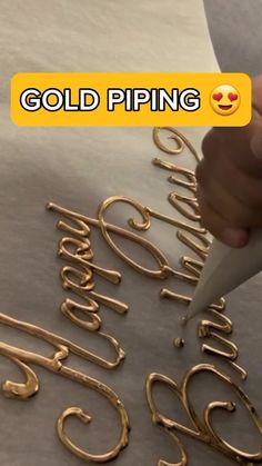 gold piping is being used to decorate letters