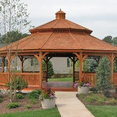 a wooden gazebo sitting on top of a lush green field