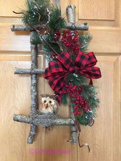 an owl is sitting in the middle of a christmas wreath hanging on a door handle