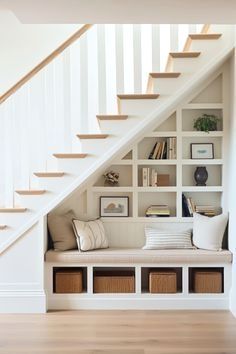 a white staircase with bookshelves and storage under it