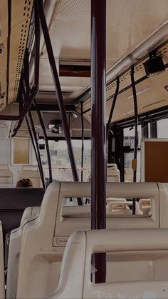 the inside of a bus with many seats and wires hanging from it's ceiling