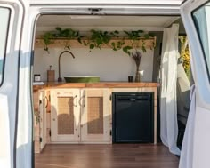 a van is parked in front of a kitchen with plants growing on the back wall