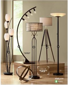 an assortment of floor lamps on display in a living room with wooden floors and walls