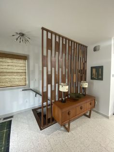 a living room filled with furniture next to a wall mounted fan and window covered in blinds