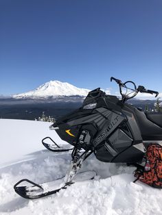 a snowmobile parked on the side of a snowy mountain