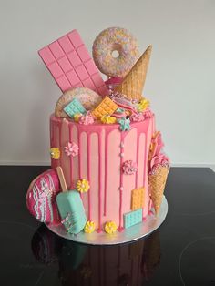 a pink cake with ice cream, doughnuts and candy