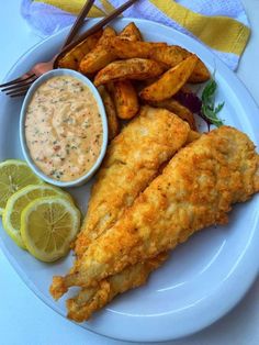 fried fish and fries on a plate with dipping sauce