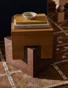 a wooden table with a book on top and a bowl sitting on top of it