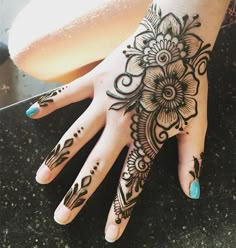 a woman's hand with henna tattoos on it