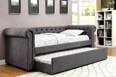 a day bed with a pull out trundle and storage underneath it in a living room