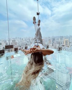 a woman standing on top of a glass floor in front of a cityscape