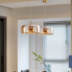 a dining room table and chairs with lights hanging from the ceiling