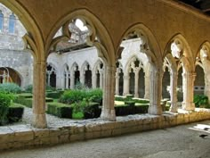 an old building with many arches and plants in it