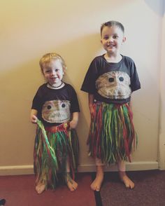 two young children dressed in grass skirts and t - shirts standing next to each other