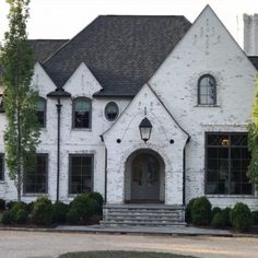 a large white brick house with black shutters