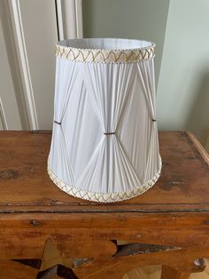 a white lamp shade sitting on top of a wooden table