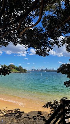 the beach is clear and blue with some boats in the water behind it on a sunny day