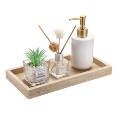 a wooden tray with two bottles, soap and an air plant on top of it