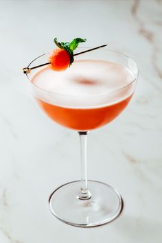 a cocktail with a cherry garnish on the rim