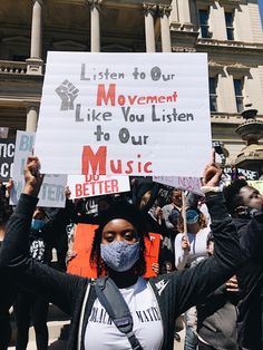 a woman holding up a sign that reads listen to our movement like you listen to our music better