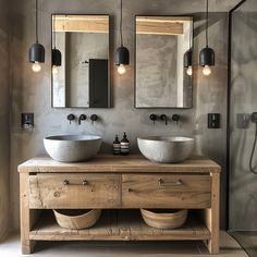 a bathroom with two sinks, mirrors and lights on the wall next to each other