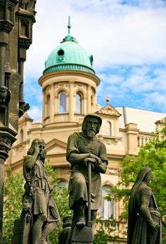 statues in front of a building with a green dome