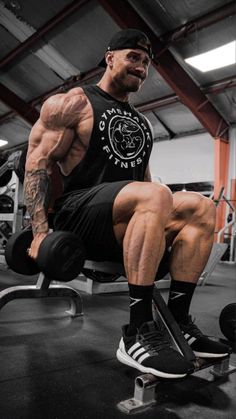 a man sitting on top of a bench in a gym