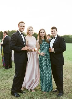 four people in formal wear posing for the camera