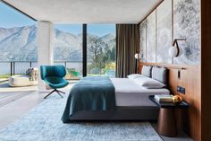 a bedroom with a large bed sitting next to a window overlooking the water and mountains