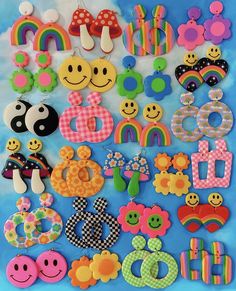 there are many different types of buttons on the blue tablecloth with rainbows, mushrooms, and flowers